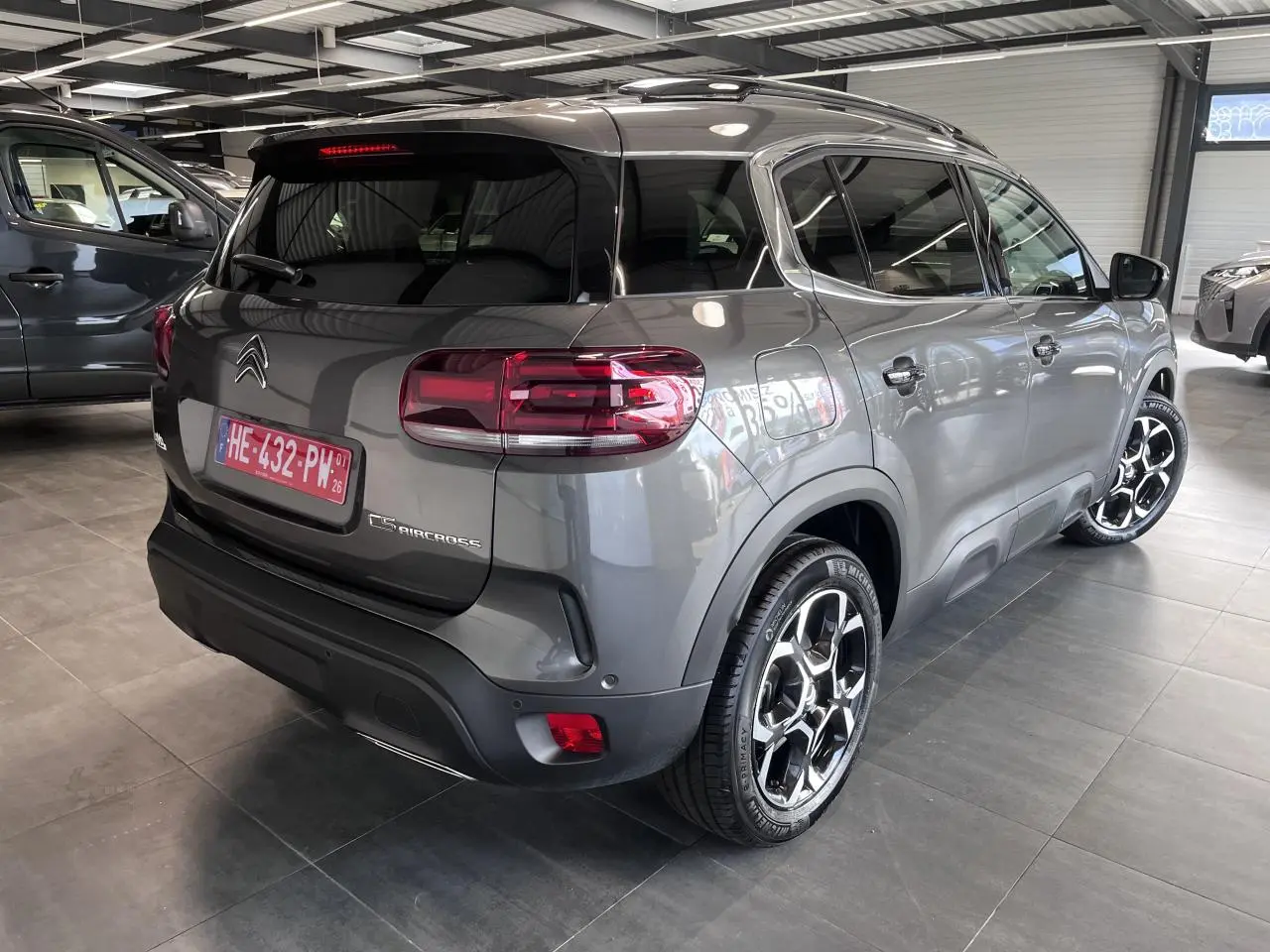 Vue 3/4 arrière droit du Citroën C5 Aircross gris platinium avec jantes alliage bi-ton et vitres surteintées.