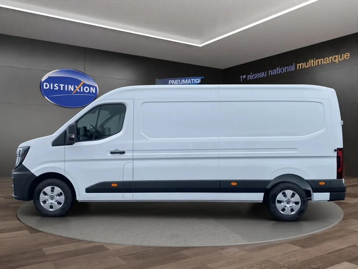 Vue de profil côté gauche d’un Renault Master blanc avec bande noire basse et jantes acier en showroom.