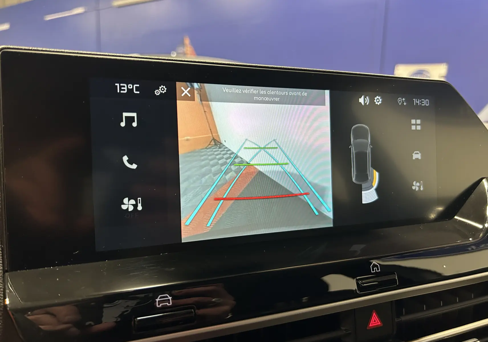 Écran central de la Citroën E-C4 2025 montrant la caméra de recul avec guidage coloré et interface tactile noire brillante.