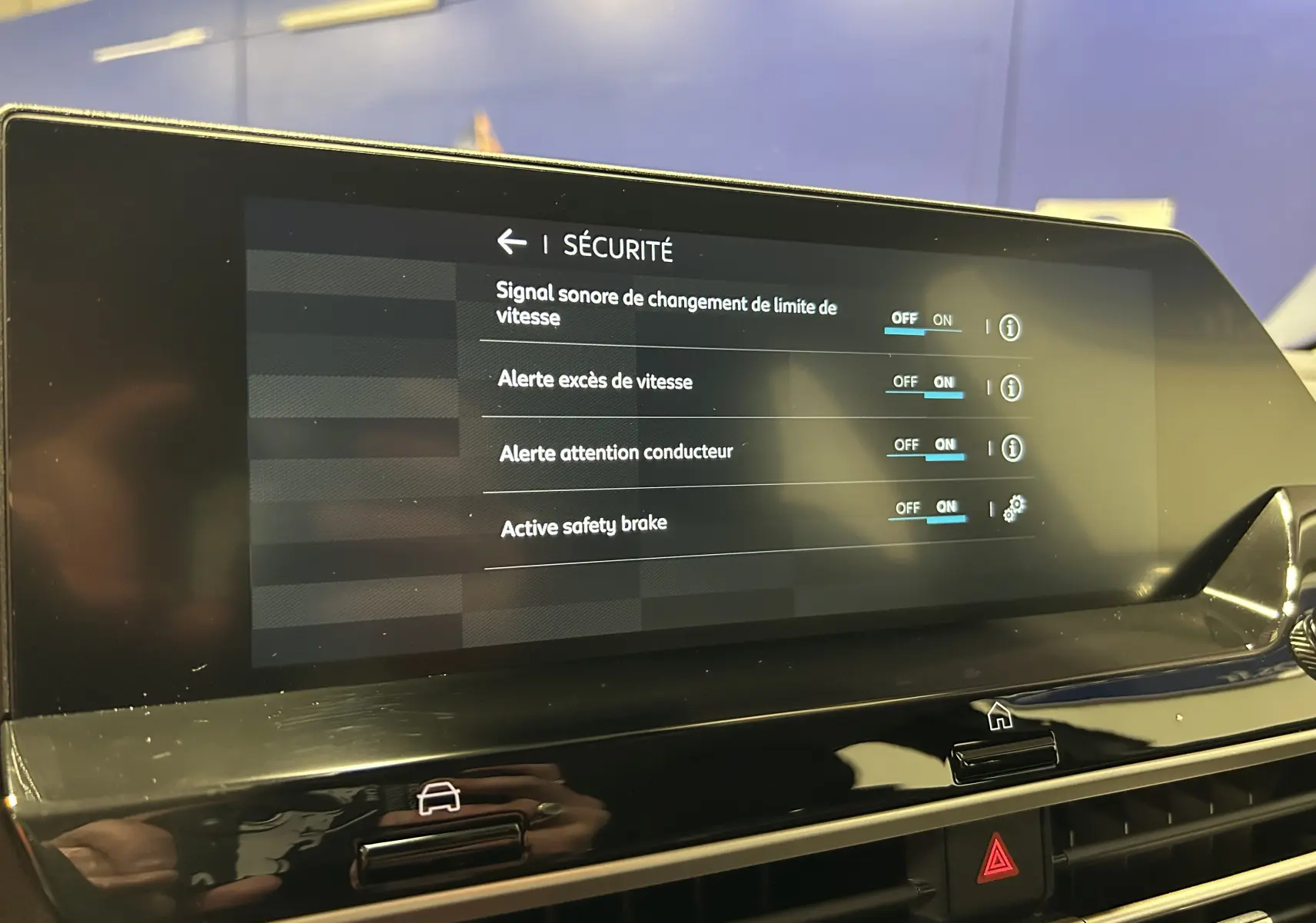Écran central de la Citroën E-C4 2025 affichant les réglages de sécurité avec options activées, intérieur noir brillant.