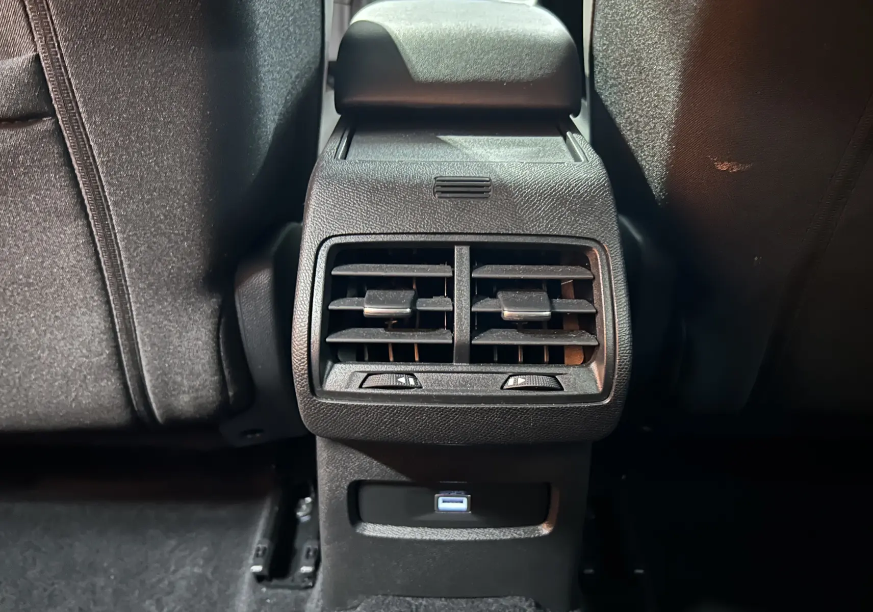 Vue rapprochée des aérateurs arrière et prise USB du Citroën E-C4 gris foncé, intérieur noir.
