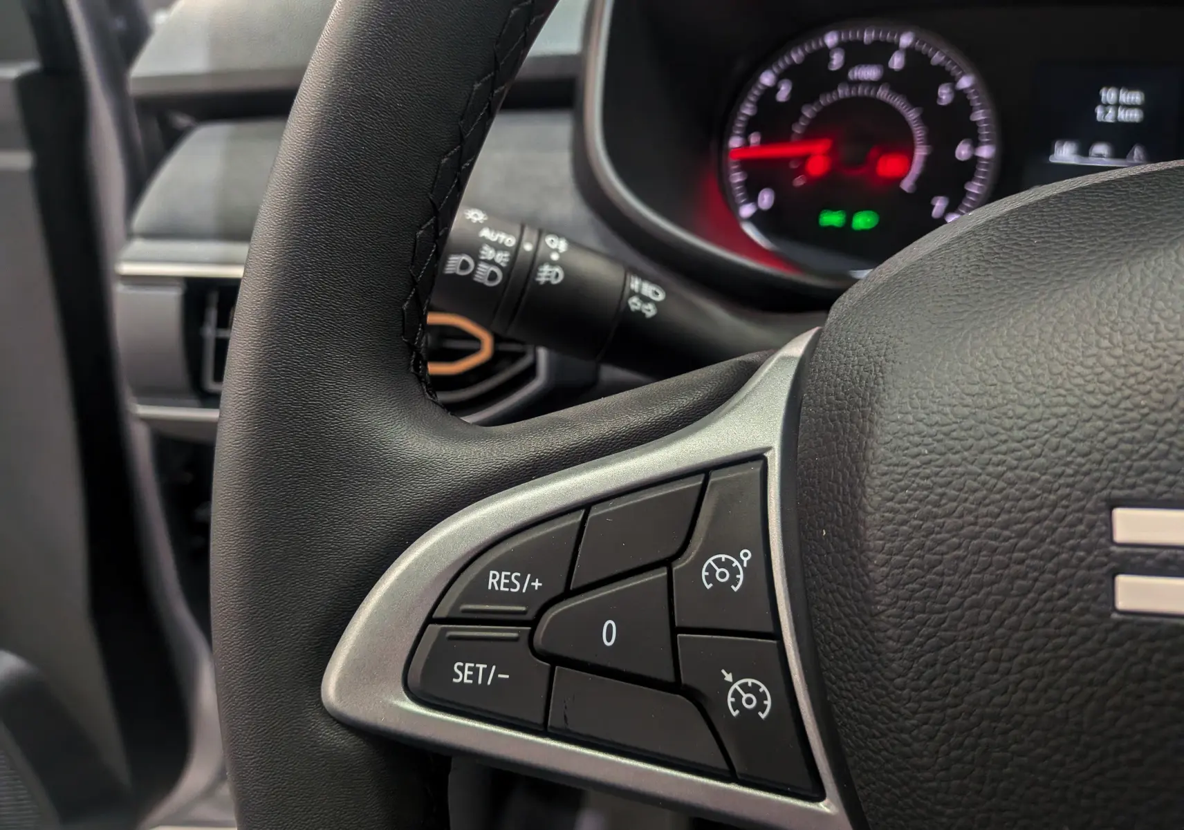 Gros plan sur le volant noir du Dacia Sandero Stepway 2025, avec commandes de régulateur de vitesse visibles à gauche.