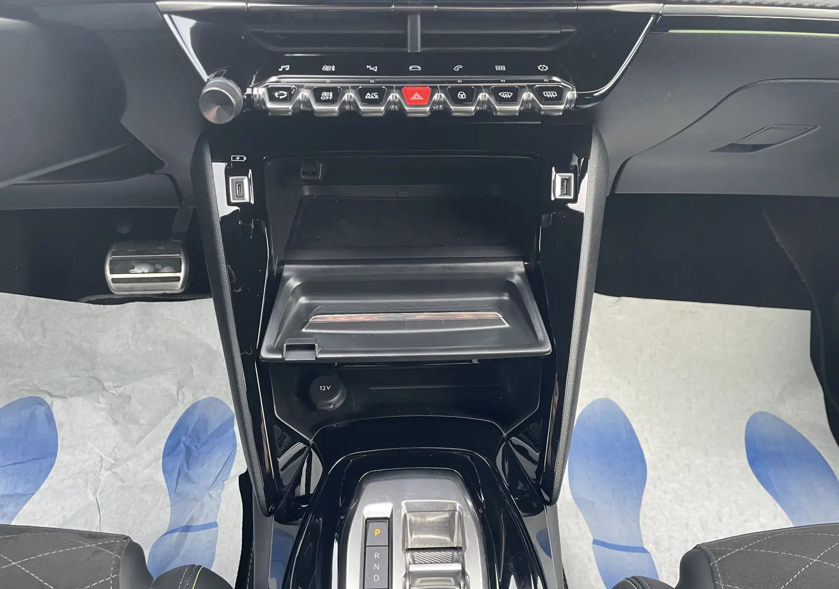 Vue rapprochée de la console centrale noire brillante de la Peugeot 2008 1.2 PureTech, avec commandes tactiles et boîte auto.