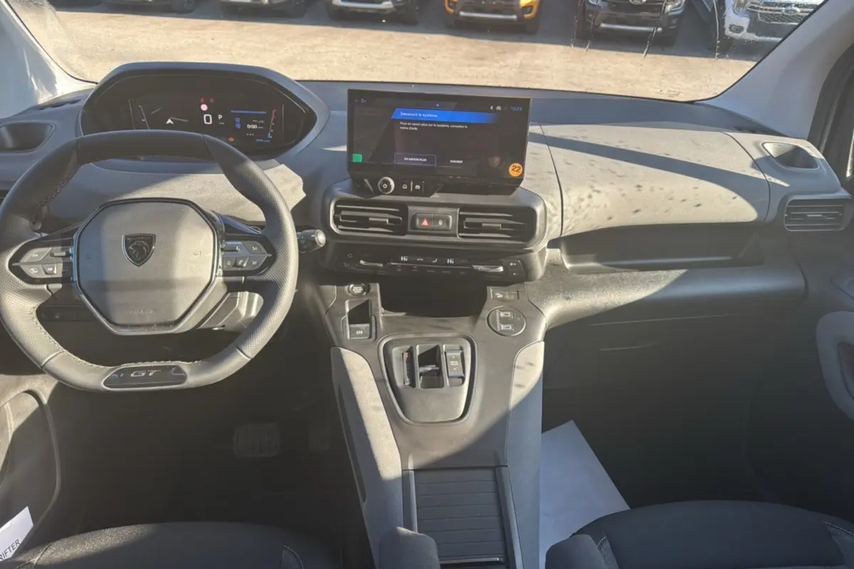 Vue intérieure avant du Peugeot Rifter GT Plus 2025 noir perla nera, avec tableau de bord digital et écran tactile central.