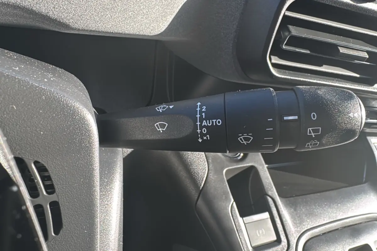 Gros plan sur la commande des essuie-glaces du Peugeot Rifter 2025, intérieur noir avec aérateurs visibles.