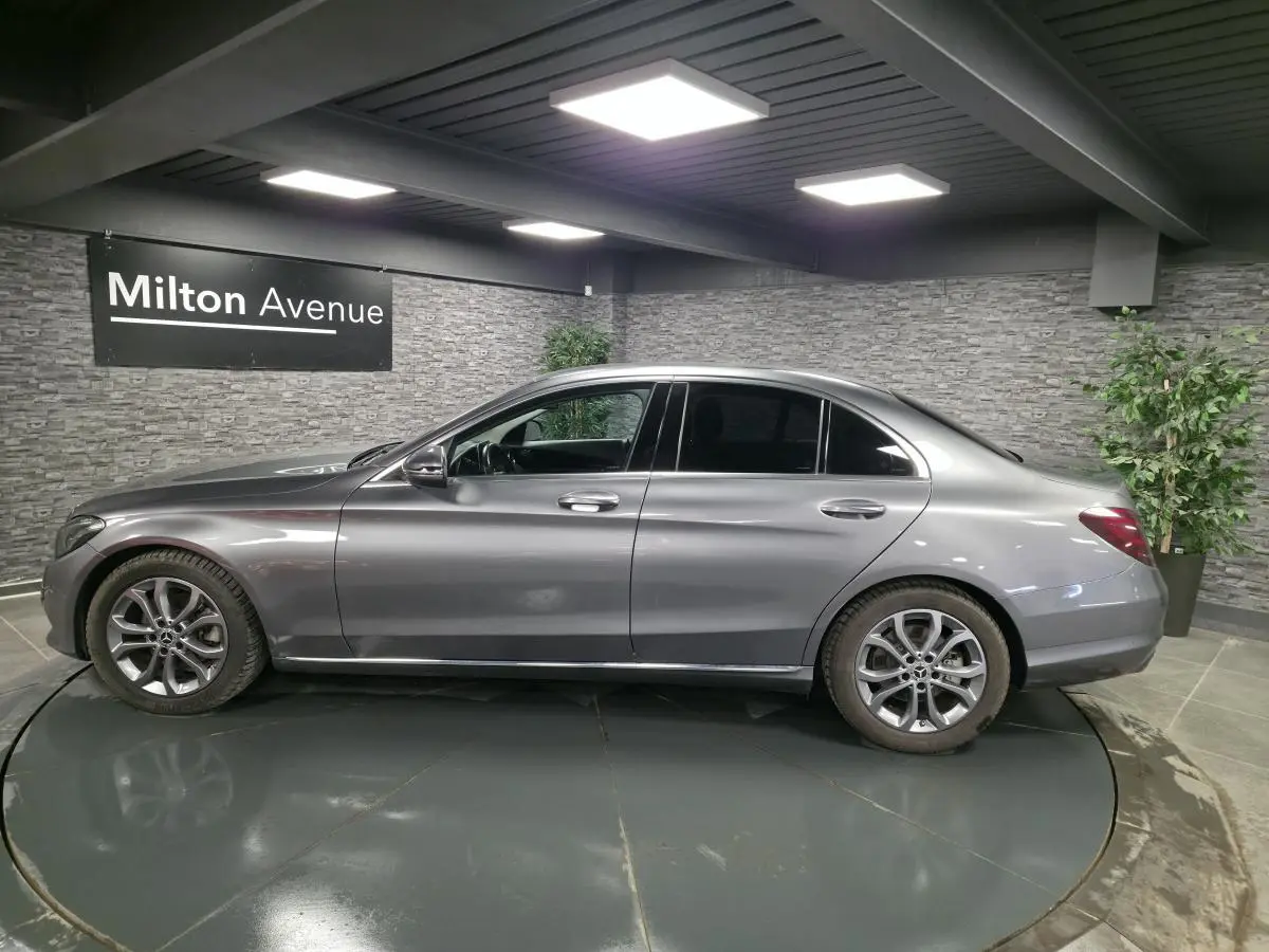 Vue latérale droite d'une Mercedes Classe C gris métallisé avec jantes alliage 17 pouces et vitres arrière teintées.