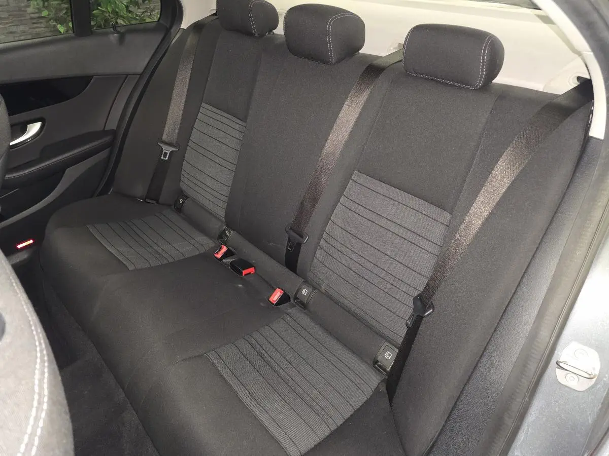 Vue intérieure de la banquette arrière en tissu gris foncé de la Mercedes Classe C 2018, avec ceintures de sécurité visibles.