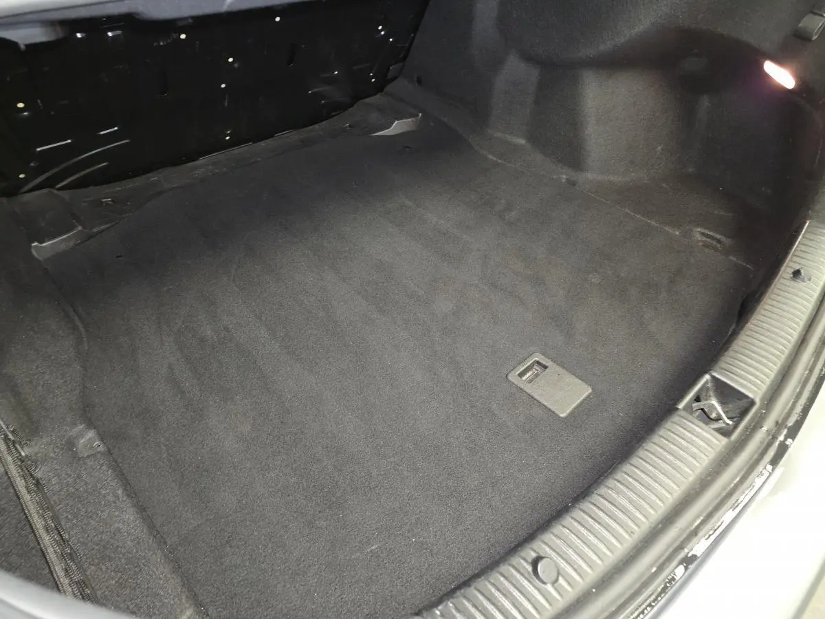 Vue plongeante sur le coffre noir propre d'une Mercedes Classe C 200 d Business gris, sans chargement visible.