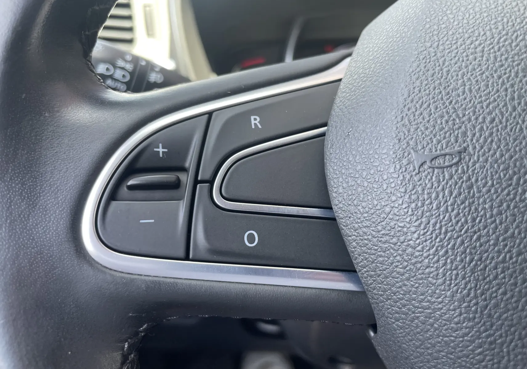 Gros plan sur les commandes au volant noir du Renault Kadjar 1.6 DCi 130 CVT Energy Intense 2018, finition cuir.