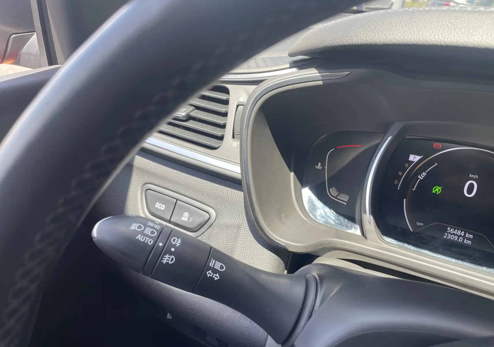 Vue intérieure du tableau de bord du Renault Kadjar rouge flamme, avec affichage numérique et commandes au volant visibles.