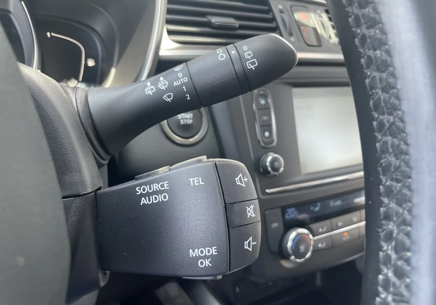 Vue rapprochée du commodo multifonction noir à gauche du volant du Renault Kadjar 2018, avec tableau de bord gris en arrière-plan.