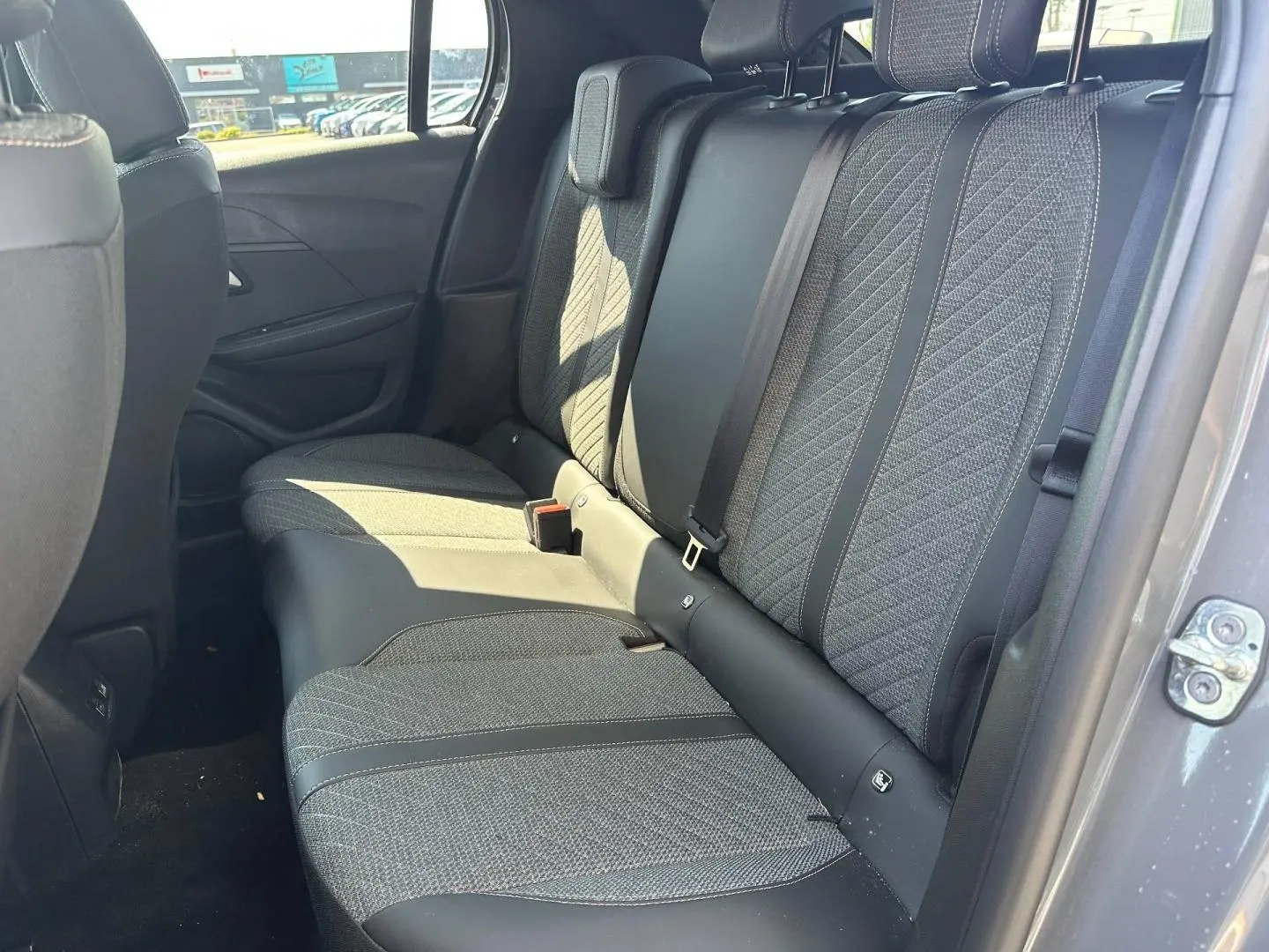 Vue intérieure côté droit sur la banquette arrière en tissu gris de la Peugeot 208 2025 finition Allure.