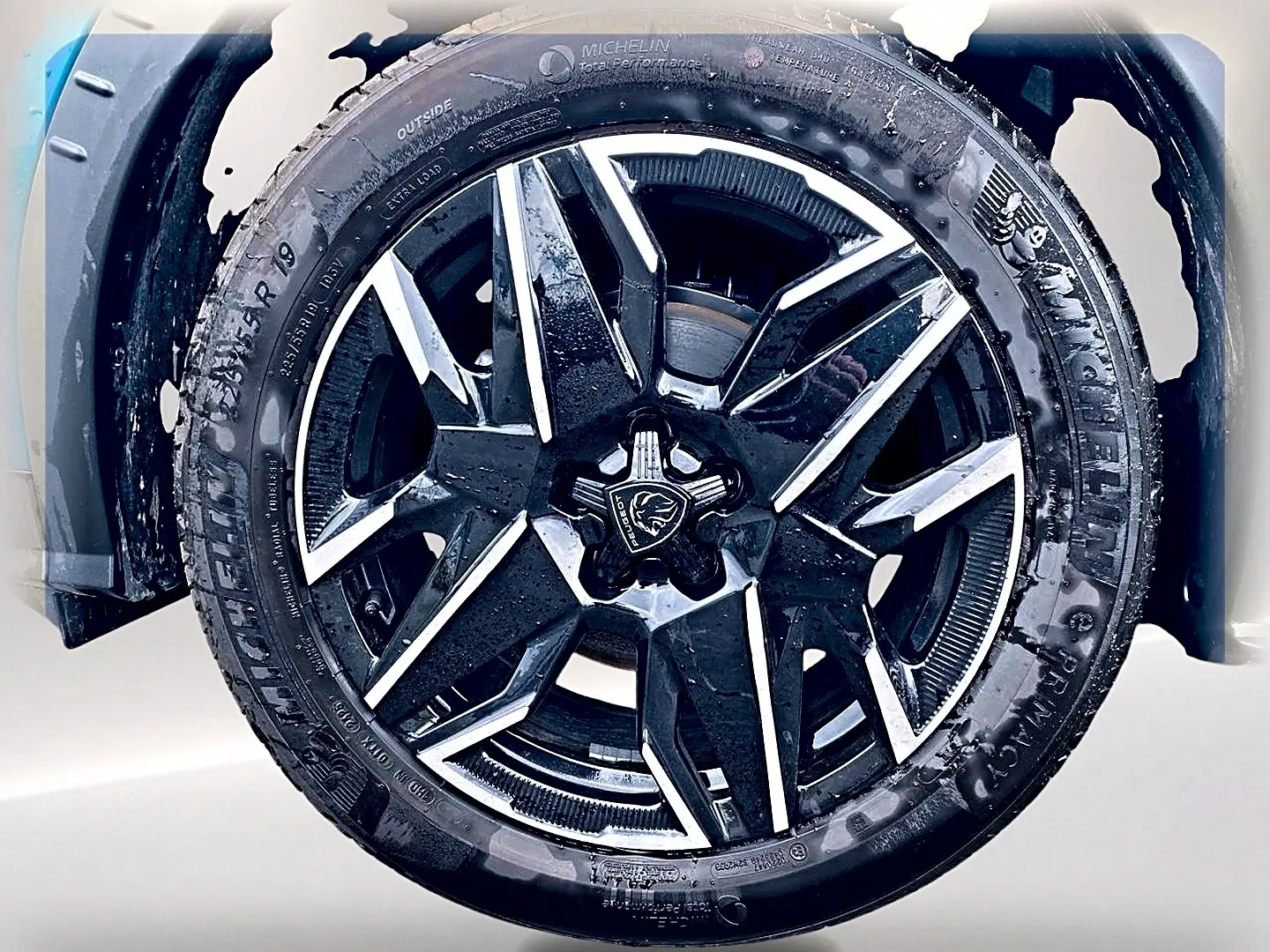 Gros plan sur la jante alu noire et argentée du côté avant gauche du Peugeot 3008 bleu 2025.