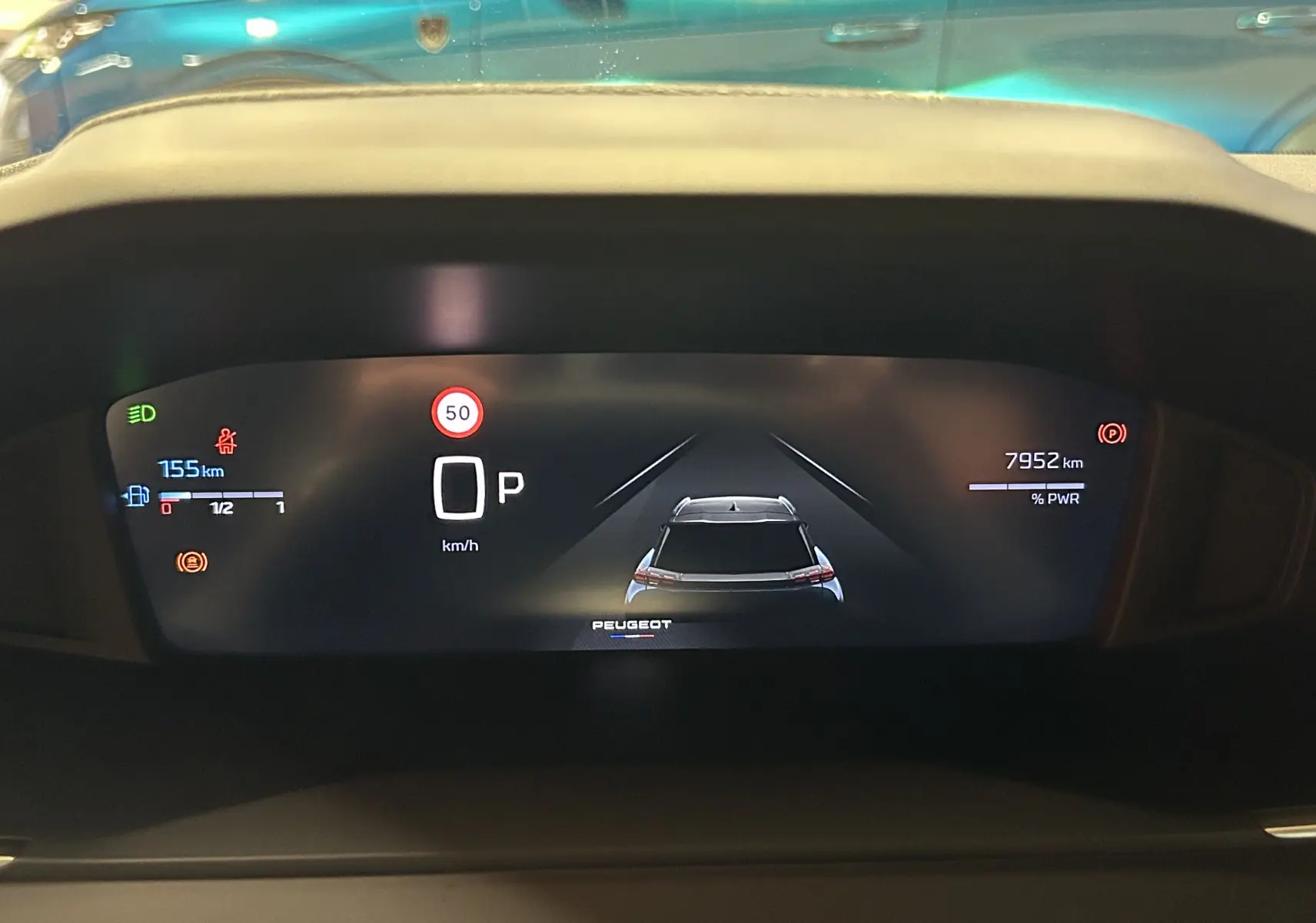 Tableau de bord numérique du Peugeot 2008 hybride noir, affichant la vitesse à 0 km/h et la caméra 360° en vue arrière.