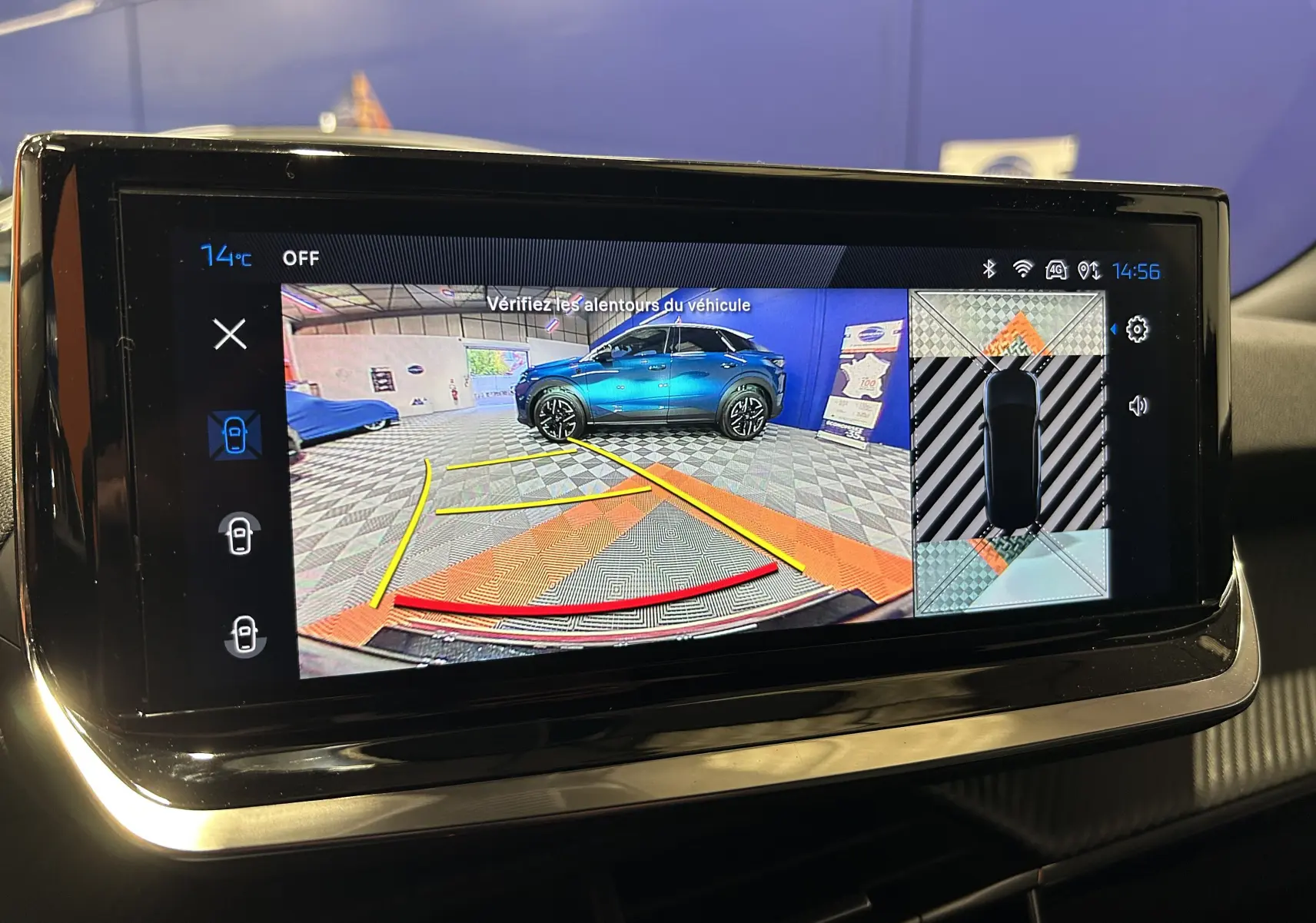 Écran de caméra 360° montrant un Peugeot 2008 noir en vue arrière avec lignes de guidage colorées.