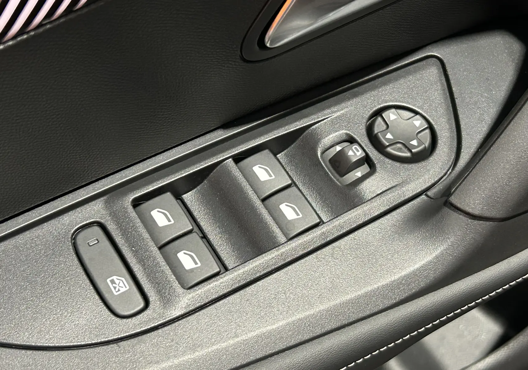 Gros plan sur les commandes de lève-vitres et réglage des rétroviseurs côté conducteur, intérieur noir du Peugeot 2008.