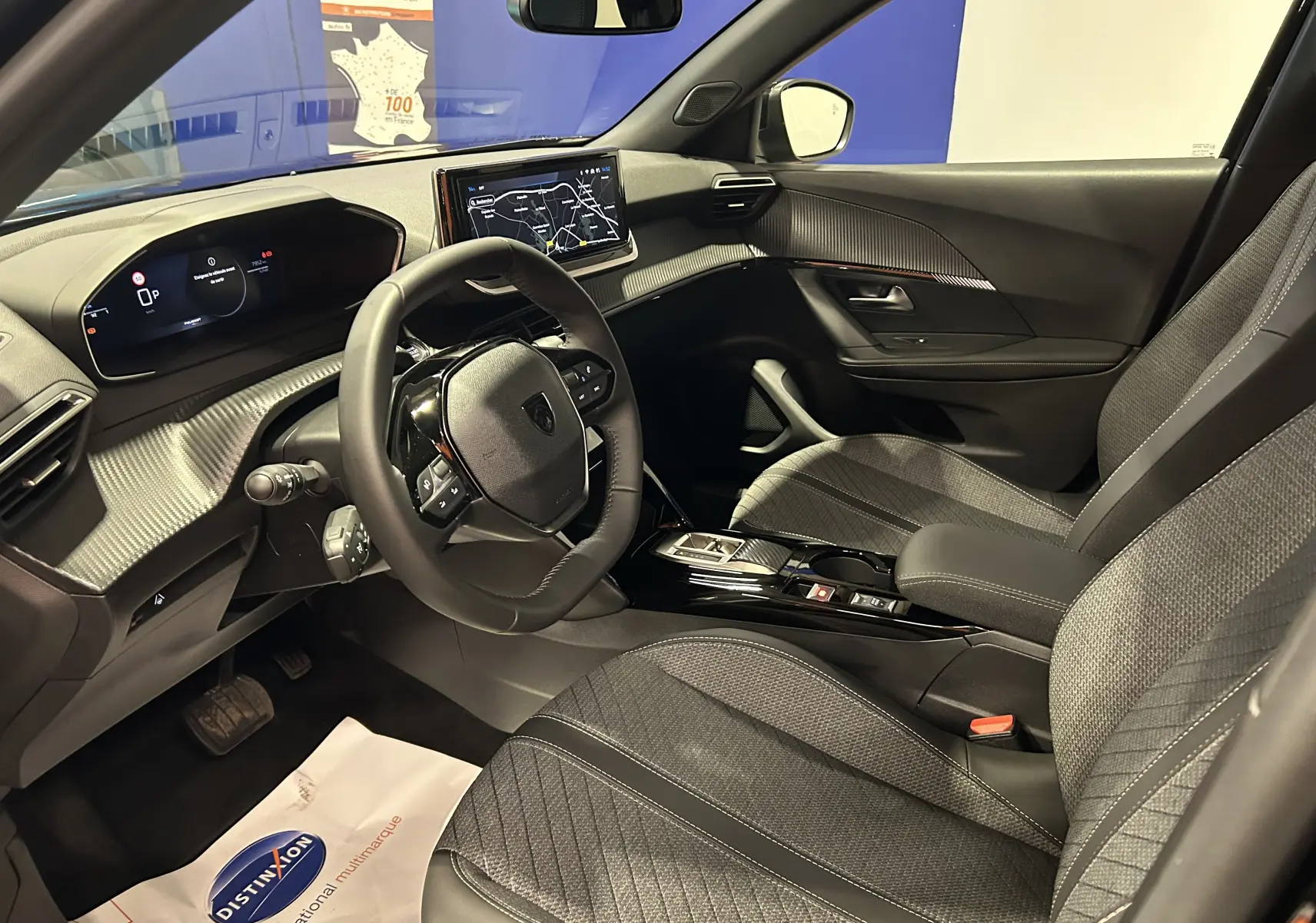Intérieur avant droit de la Peugeot 2008 II Hybrid noir, avec tableau de bord numérique et écran tactile GPS.