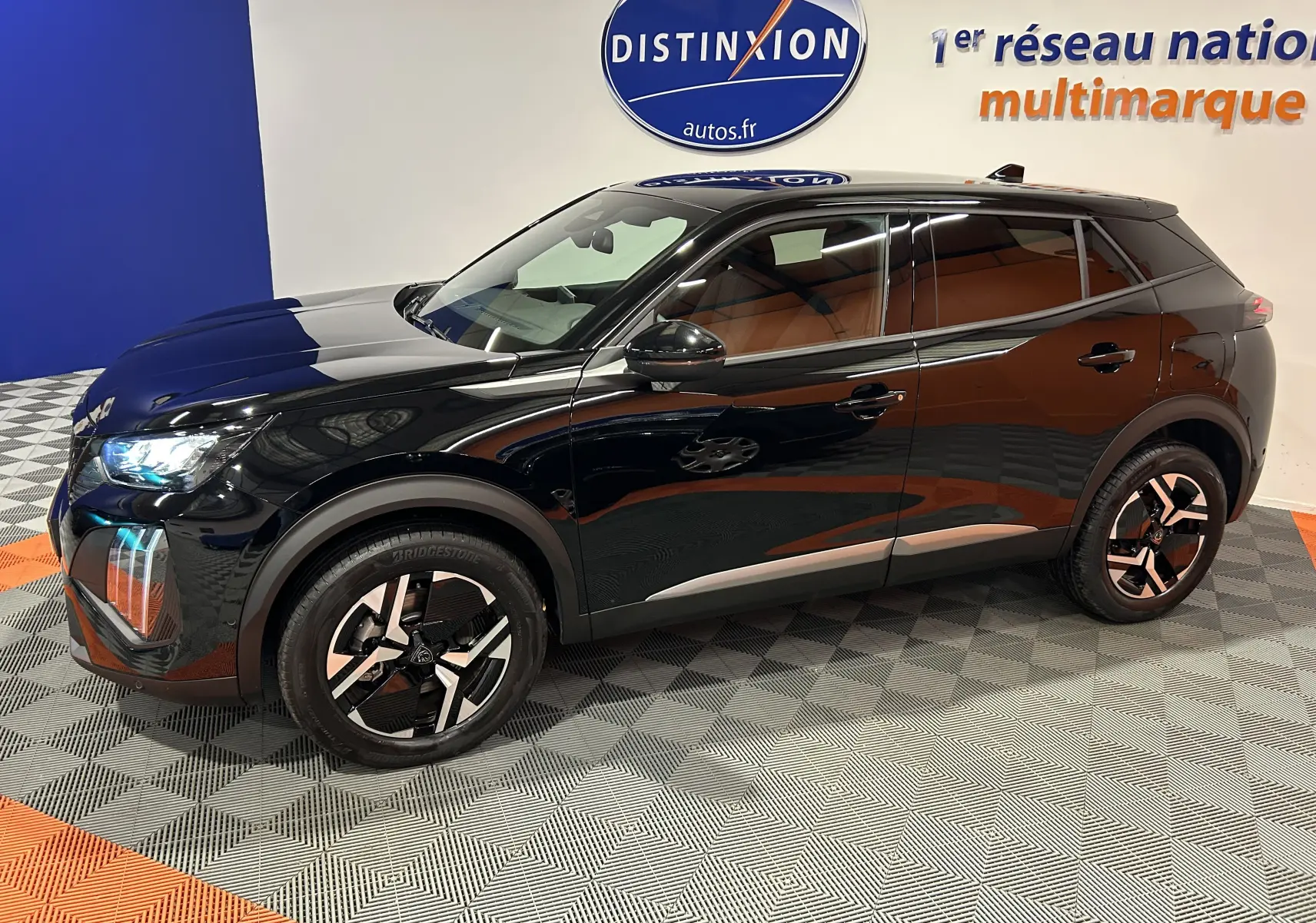 Peugeot 2008 II Hybrid noir en 3/4 avant droit, avec jantes alliage distinctives et vitres teintées.