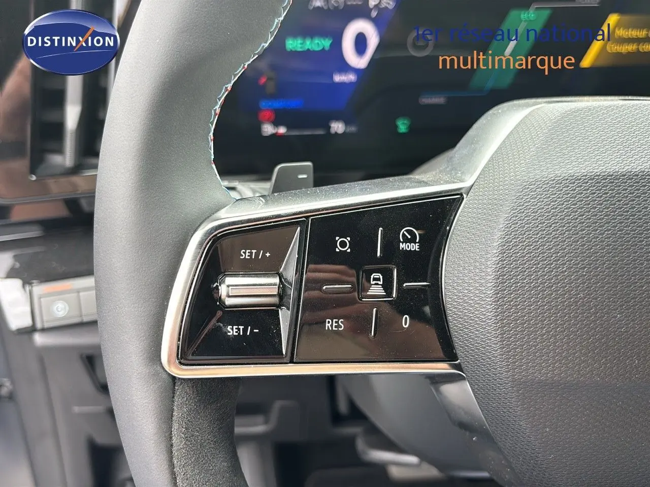 Gros plan sur les commandes du volant à gauche du Renault Austral gris schiste satin mat 2024, affichage numérique en arrière-plan.