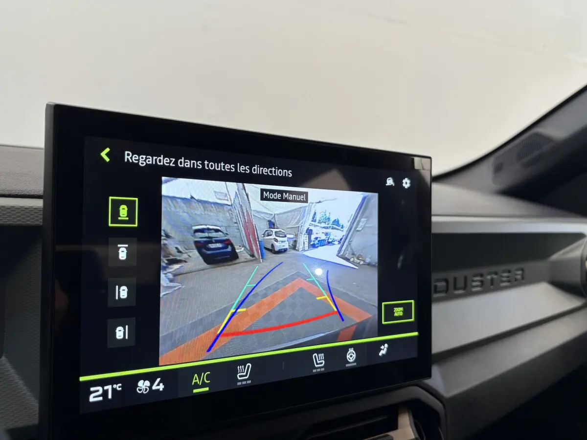 Écran tactile central du Dacia Duster noir 2025 montrant la caméra de recul avec guidage de trajectoire coloré.