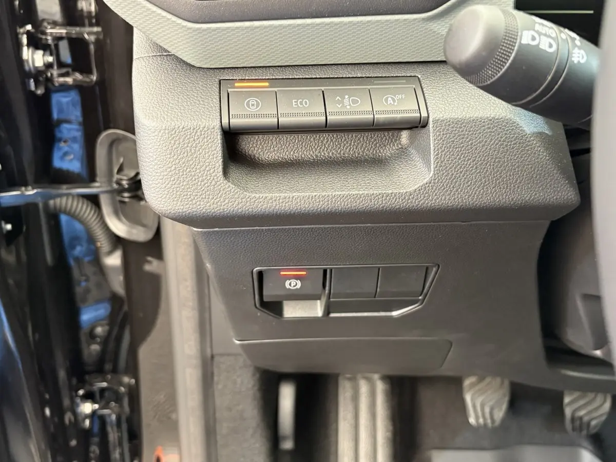 Détail du tableau de bord noir du Dacia Duster 2025 avec commandes ECO et frein de stationnement électrique.