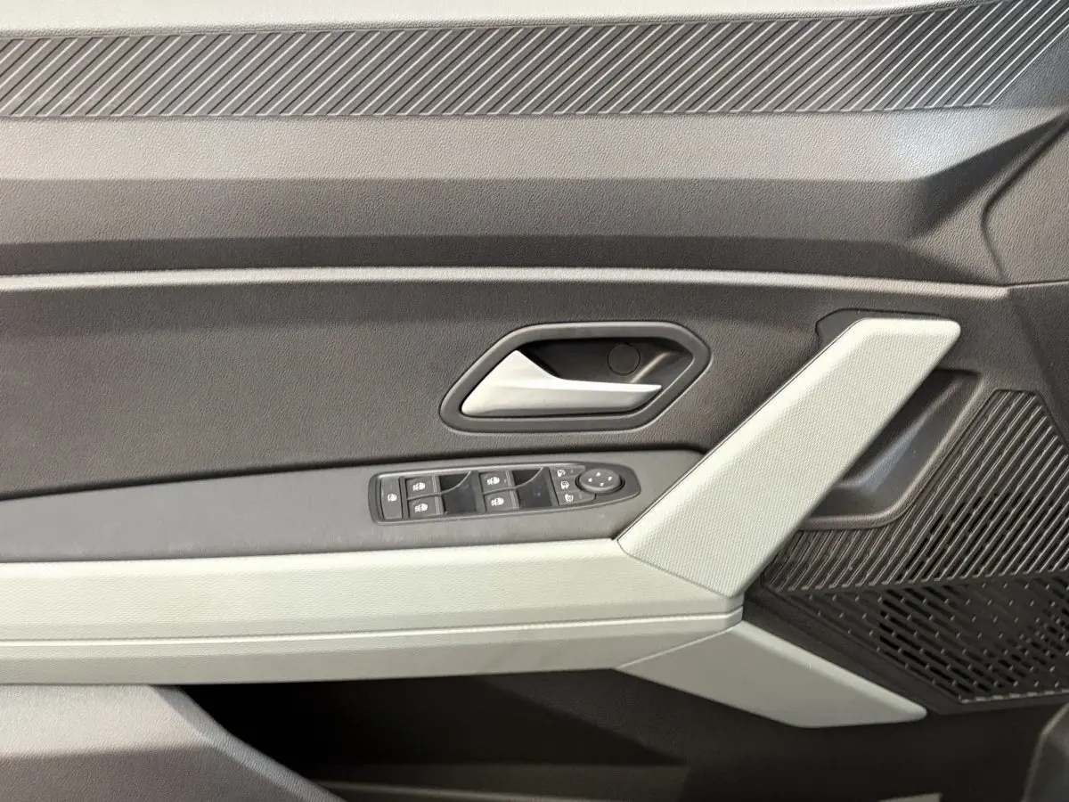 Gros plan sur la porte côté gauche du Dacia Duster noir 2025, avec commandes de vitres et poignée argentée.