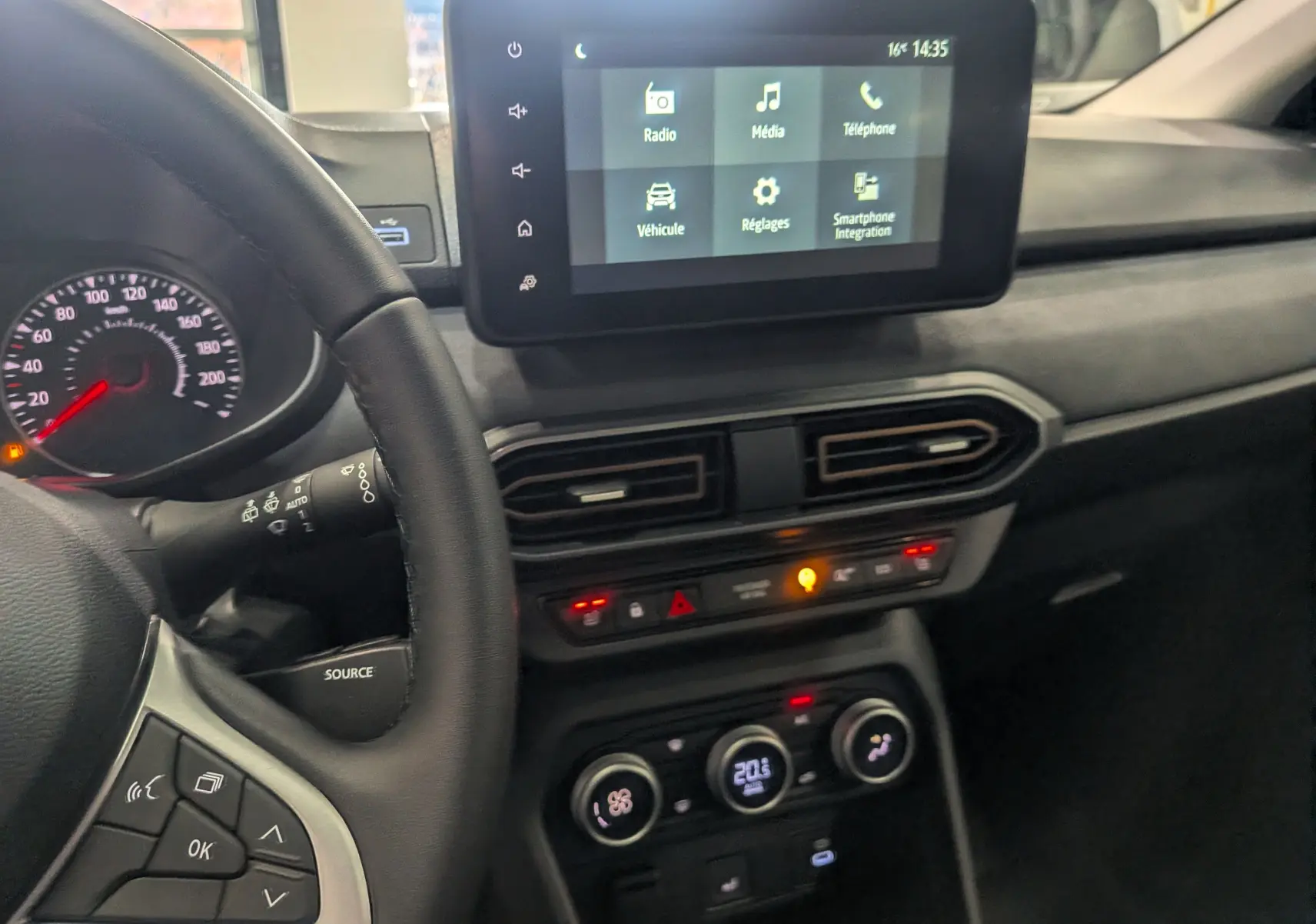 Intérieur du tableau de bord de la Dacia Sandero Stepway TCe 110, avec écran tactile et commandes climatisation visibles.