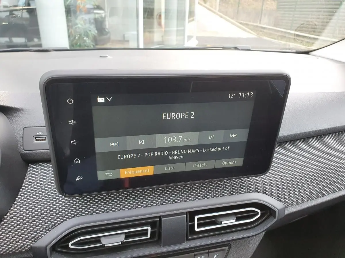 Écran tactile central du tableau de bord du Dacia Jogger 2024 affichant la radio Europe 2, avec finition texturée grise.