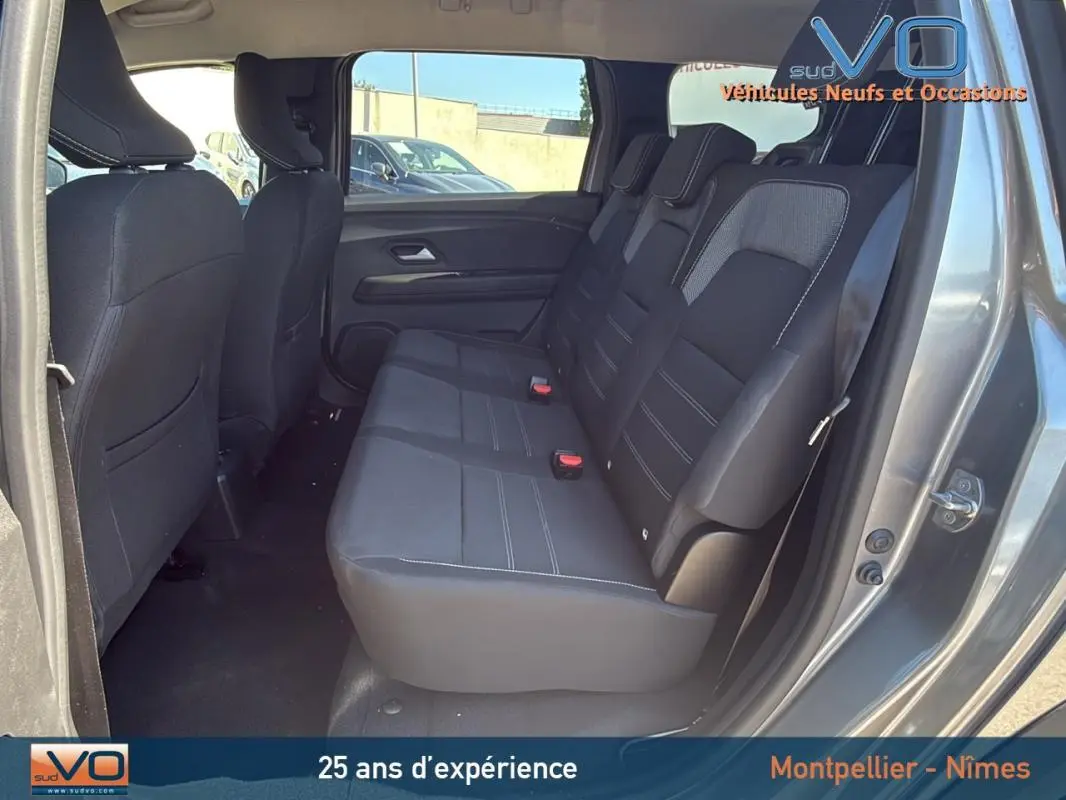 Vue intérieure côté droit sur la banquette arrière noire du Dacia Jogger gris 2025, avec porte ouverte.