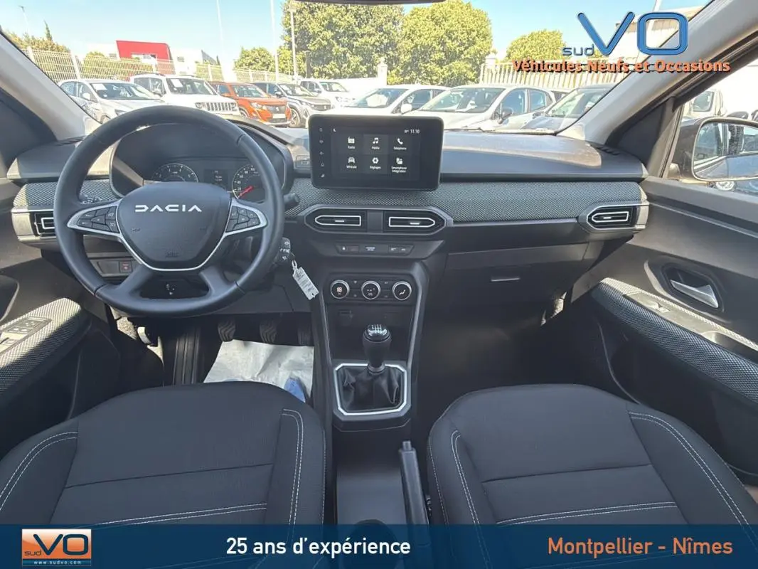 Vue intérieure avant du Dacia Jogger TCe 110 gris, montrant le tableau de bord avec écran tactile et volant multifonction.