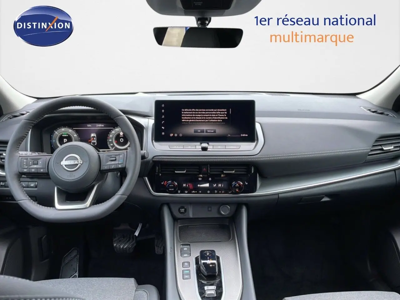 Intérieur du Nissan Qashqai 2025 gris, vue frontale sur le tableau de bord moderne avec écran tactile et volant multifonction.