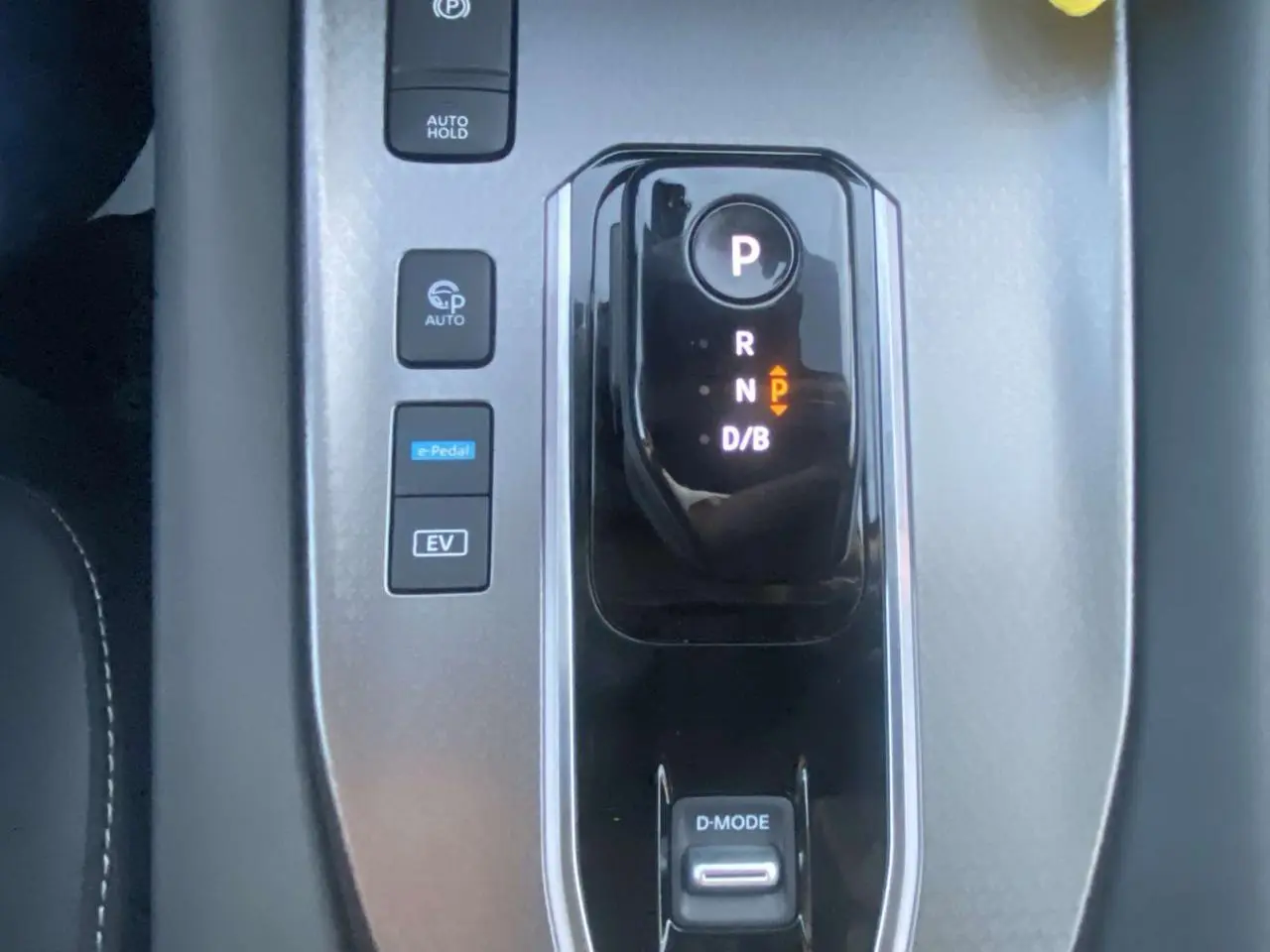 Gros plan sur la console centrale du Nissan Qashqai 2025 gris ceramic, montrant la boîte auto et les boutons de commande.