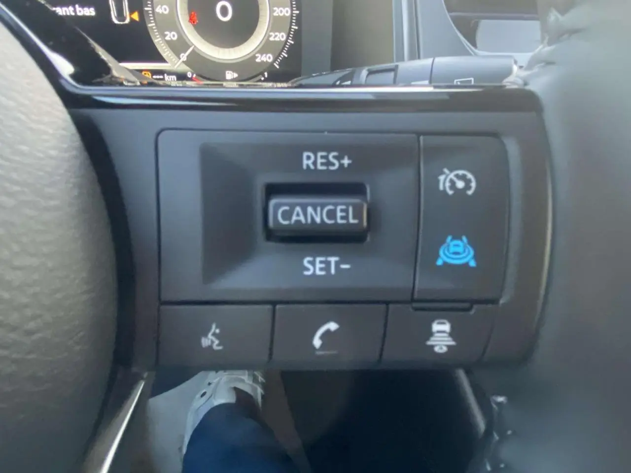 Gros plan sur les commandes au volant côté droit du Nissan Qashqai gris ceramic 2025 avec régulateur de vitesse et aides à la conduite.