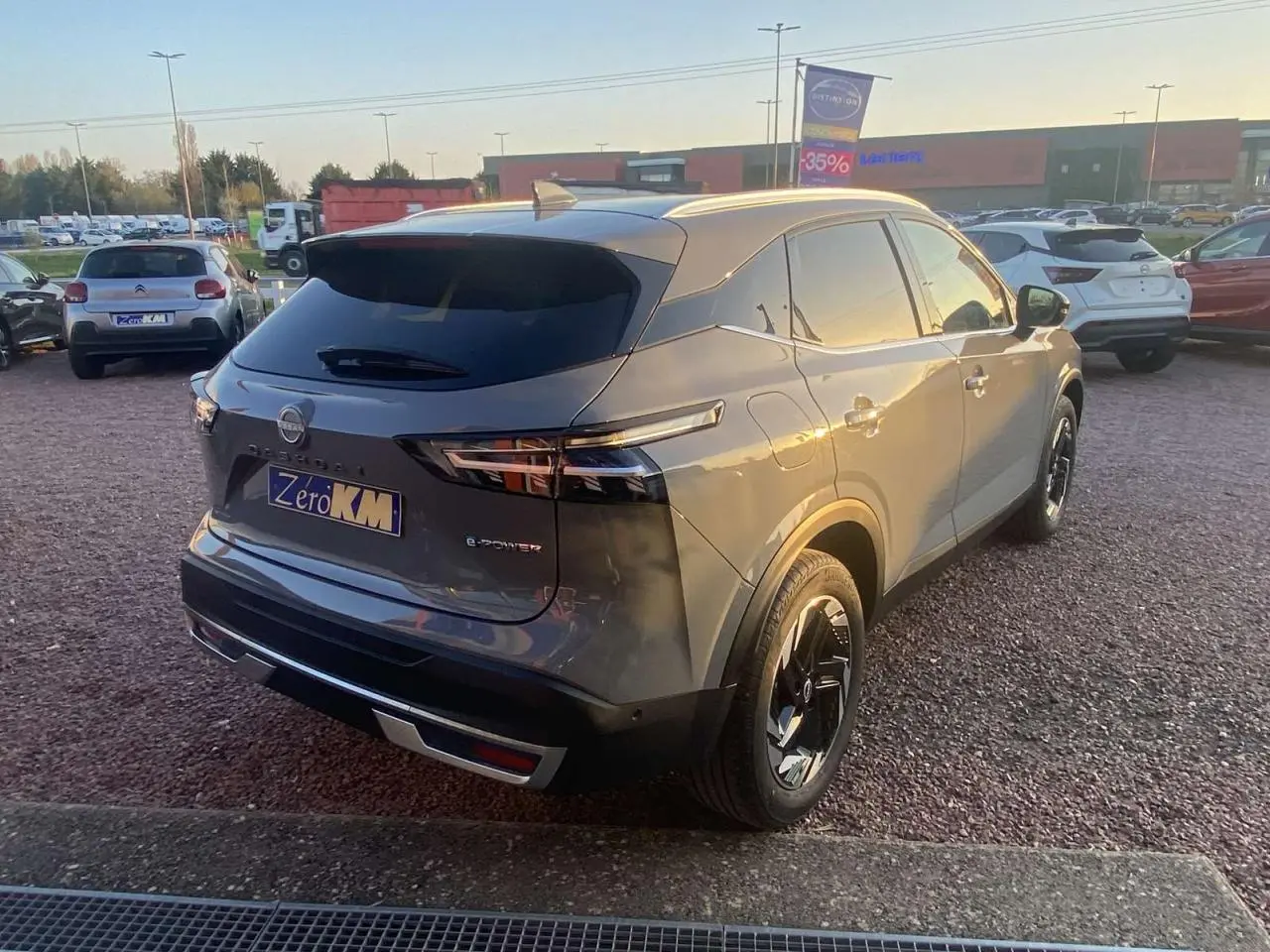 Vue 3/4 arrière droite du Nissan Qashqai 2025 gris ceramic avec détails noirs et feux arrière LED distinctifs.