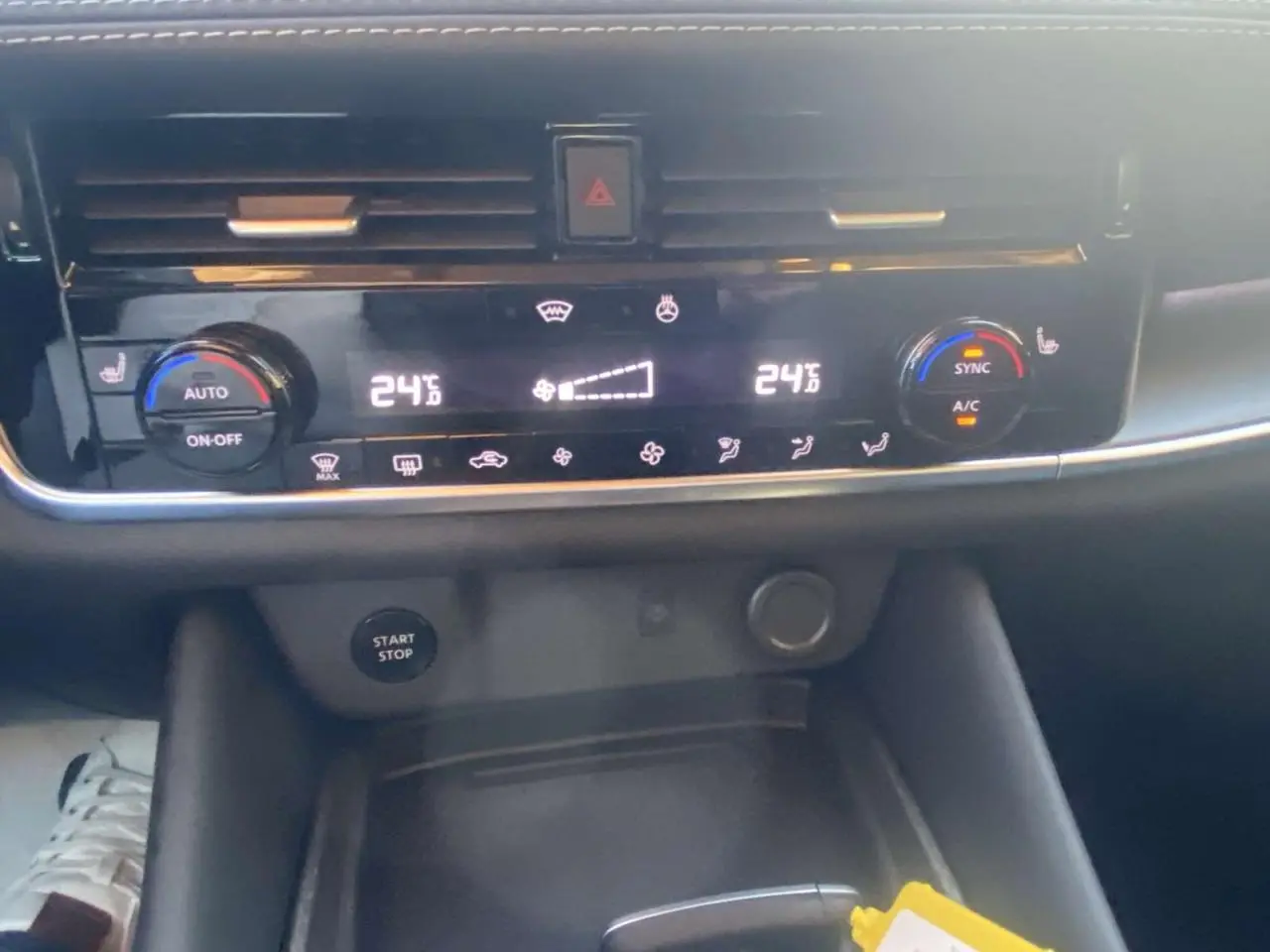 Vue rapprochée du tableau de bord du Nissan Qashqai 2025, montrant la climatisation digitale à 24°C et le bouton Start/Stop.