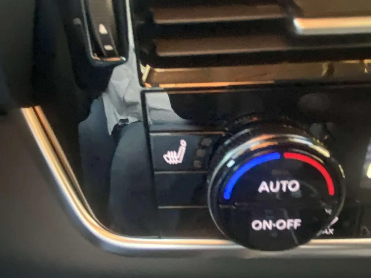 Gros plan sur la molette de réglage de la climatisation automatique avec fonction siège chauffant du Nissan Qashqai gris ceramic.