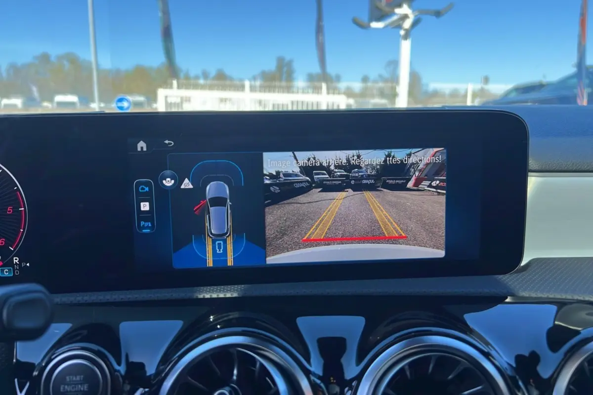 Vue intérieure du tableau de bord de la Mercedes Classe A 200D avec écran affichant la caméra de recul en marche.