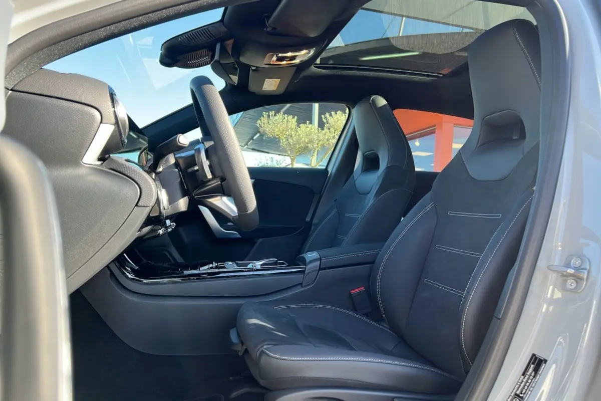 Vue intérieure côté conducteur de la Mercedes Classe A 200D BVA Exclusive Design avec sièges sport cuir tissu et toit panoramique.