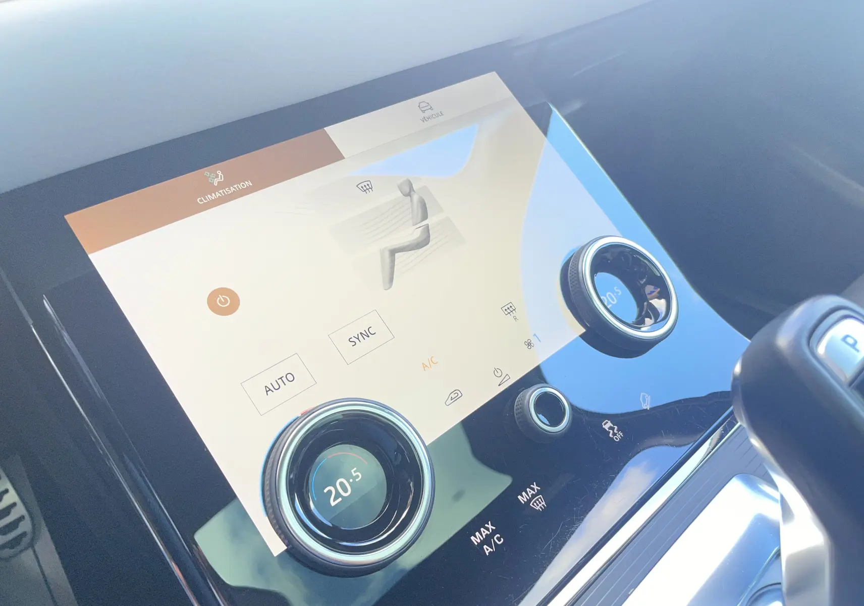 Gros plan sur la console centrale du Range Rover Evoque 2022 en Portofino Blue, affichant la climatisation digitale à 20,5°C.