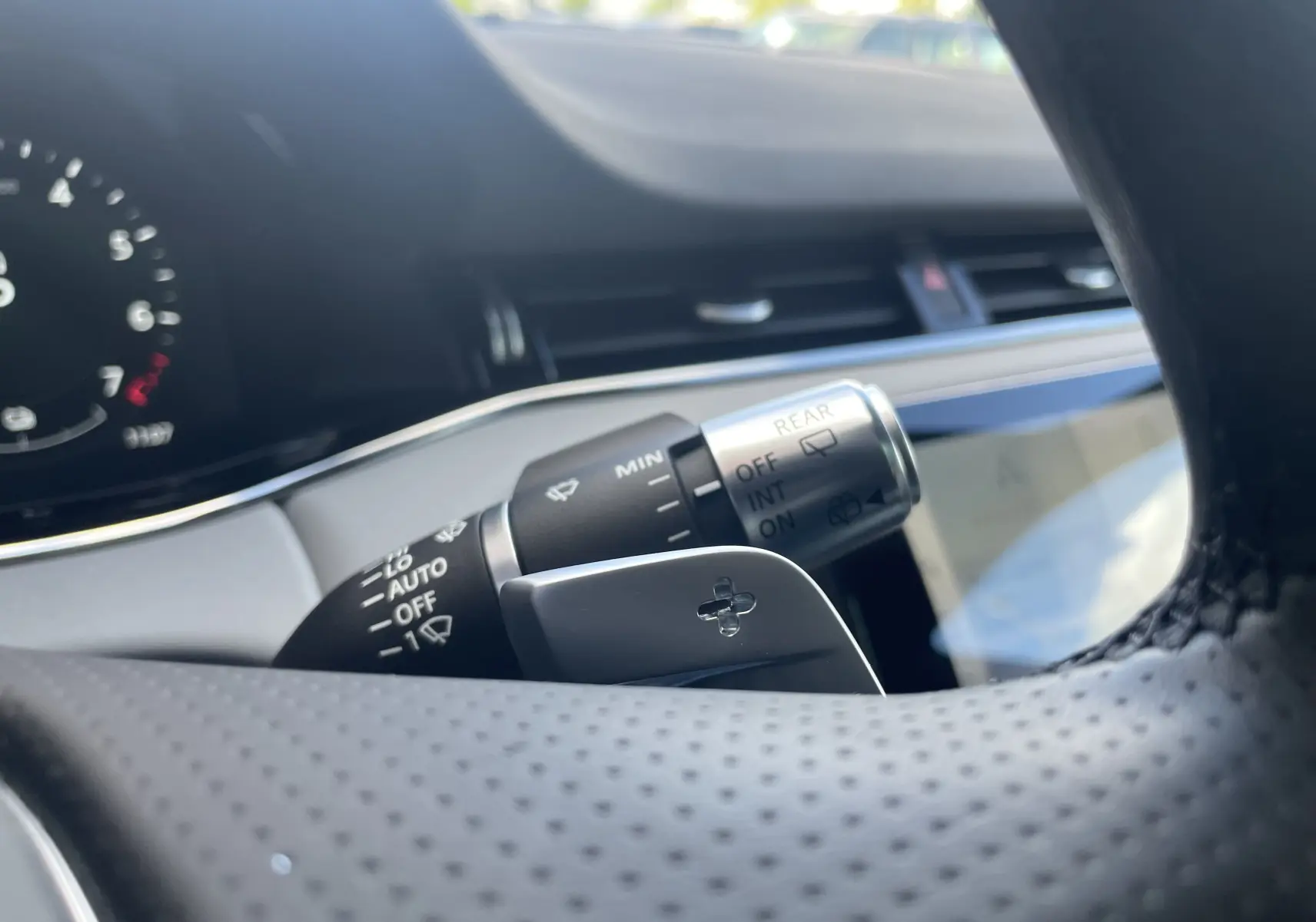 Gros plan sur la commande d’essuie-glace et la palette de changement de vitesse côté droit du volant perforé du Range Rover Evoque 2022.