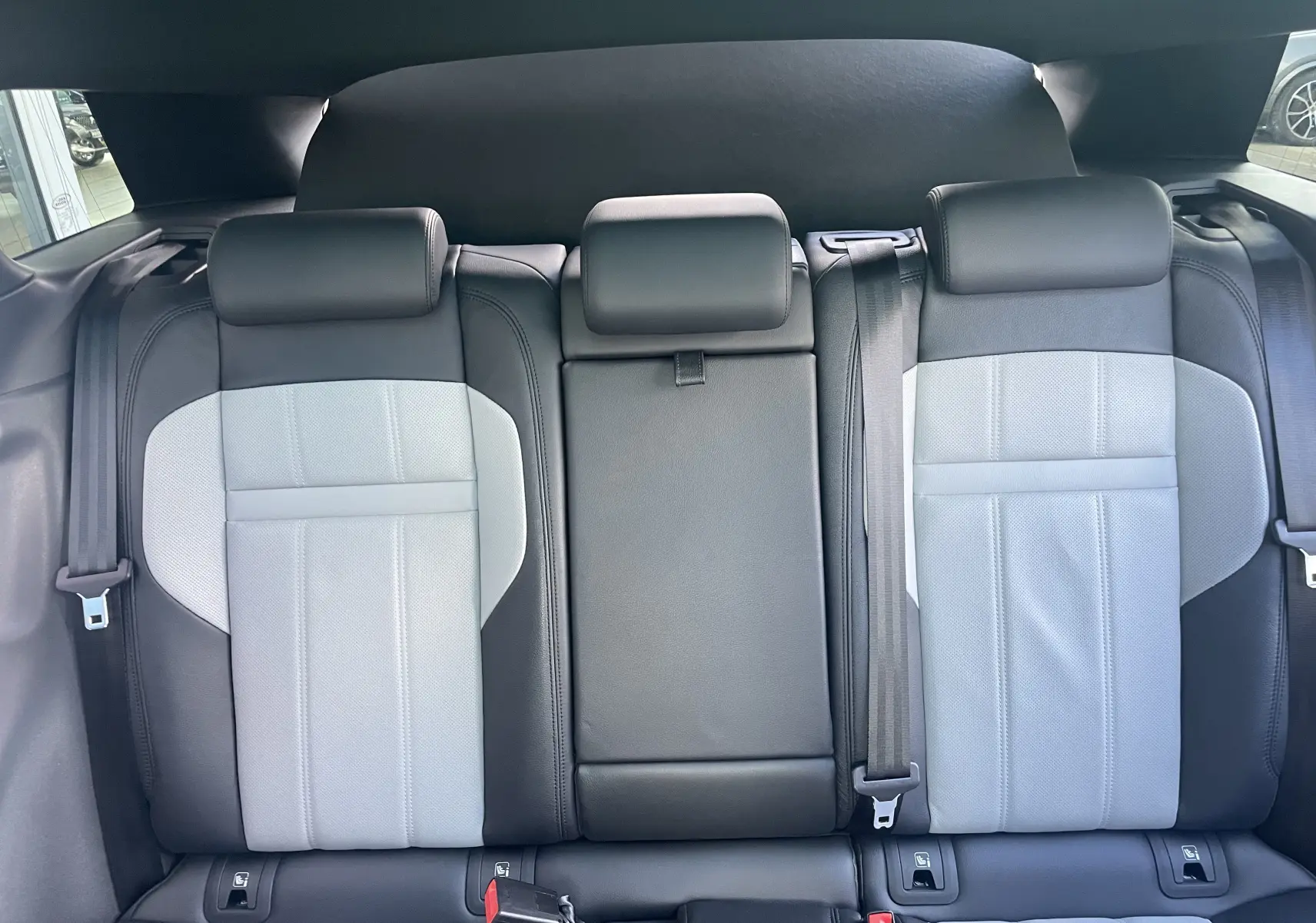 Vue intérieure arrière montrant les sièges en cuir bi-ton gris clair et noir du Range Rover Evoque 2022.