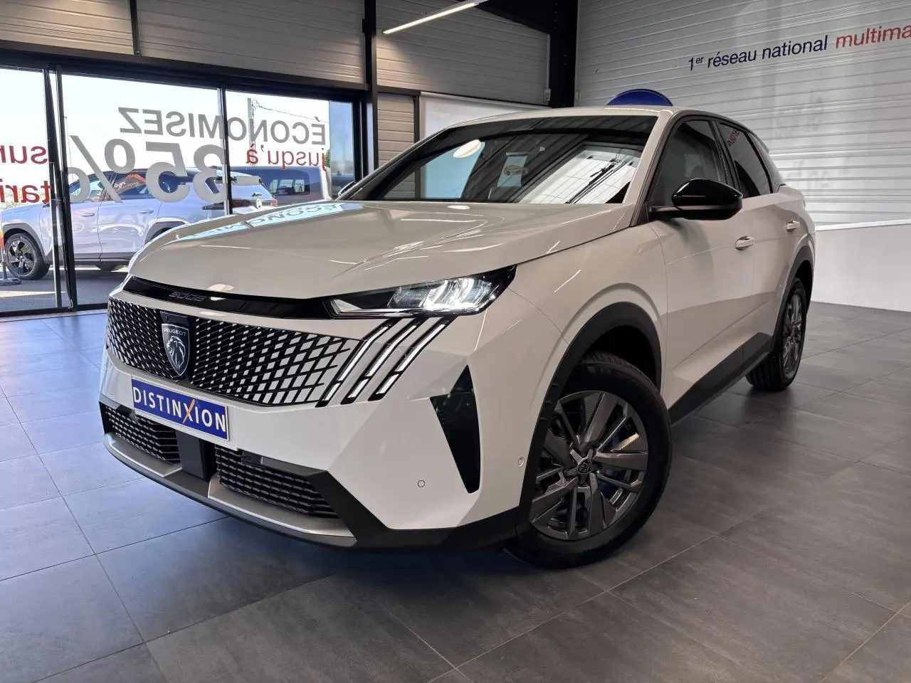 Peugeot 3008 blanc en 3/4 avant droit, avec calandre noire à motif géométrique et jantes alliage 18 pouces.