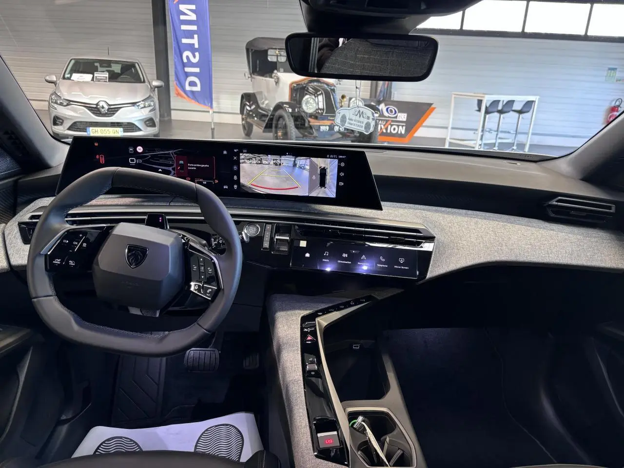 Vue intérieure du poste de conduite du Peugeot 3008 blanc, avec tableau de bord numérique panoramique et volant compact cuir.