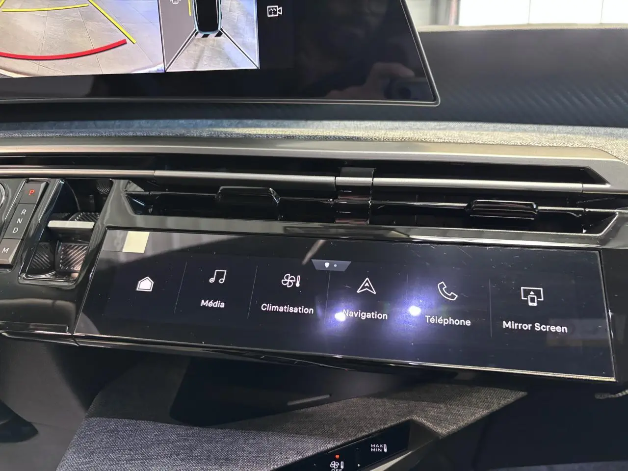 Vue rapprochée de la console centrale noire laquée du Peugeot 3008 blanc avec écran tactile multimédia et commandes digitales.