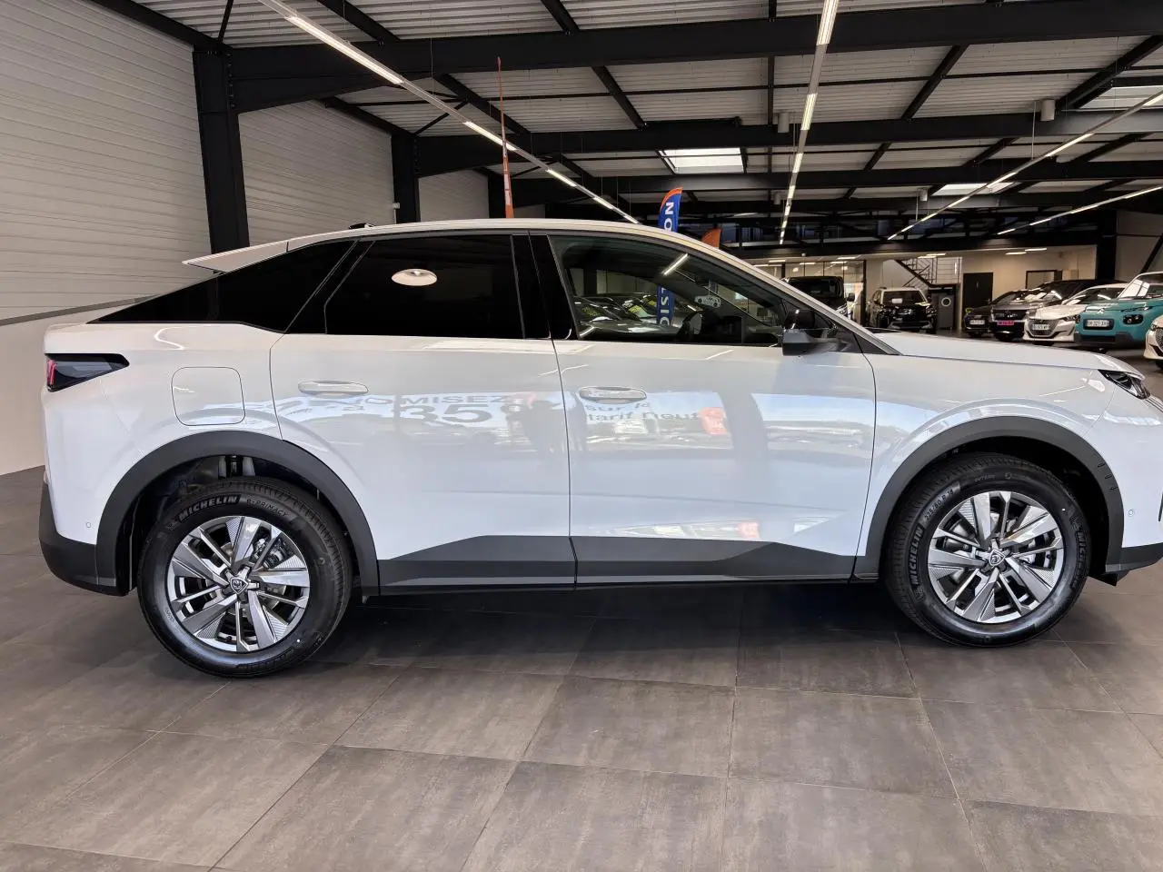 Vue latérale droite d’un Peugeot 3008 blanc hybride 2026 avec jantes alliage 18 pouces et vitres arrière teintées.