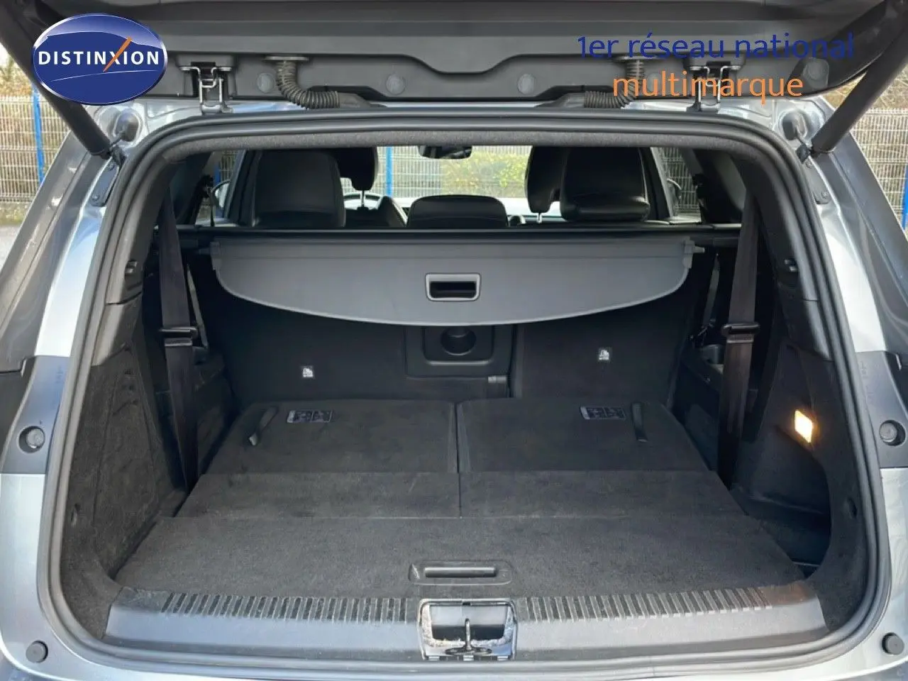 Coffre ouvert en vue arrière du Renault Espace gris schiste, plancher plat avec sièges rabattus et cache-bagages déployé.