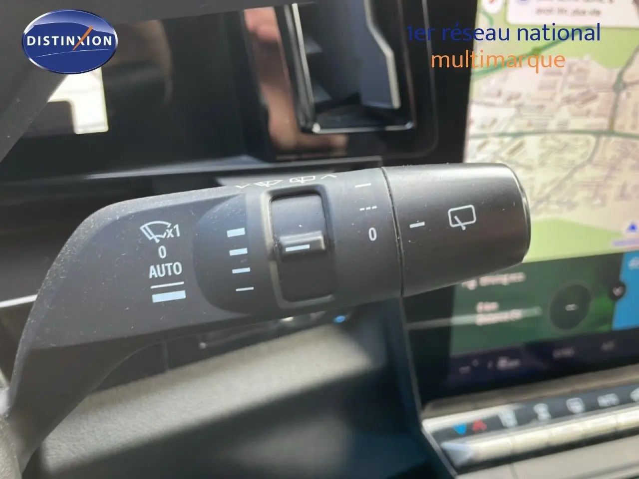 Gros plan sur la commande des essuie-glaces dans l'habitacle du Renault Espace gris schiste 2024, avec écran tactile en arrière-plan.