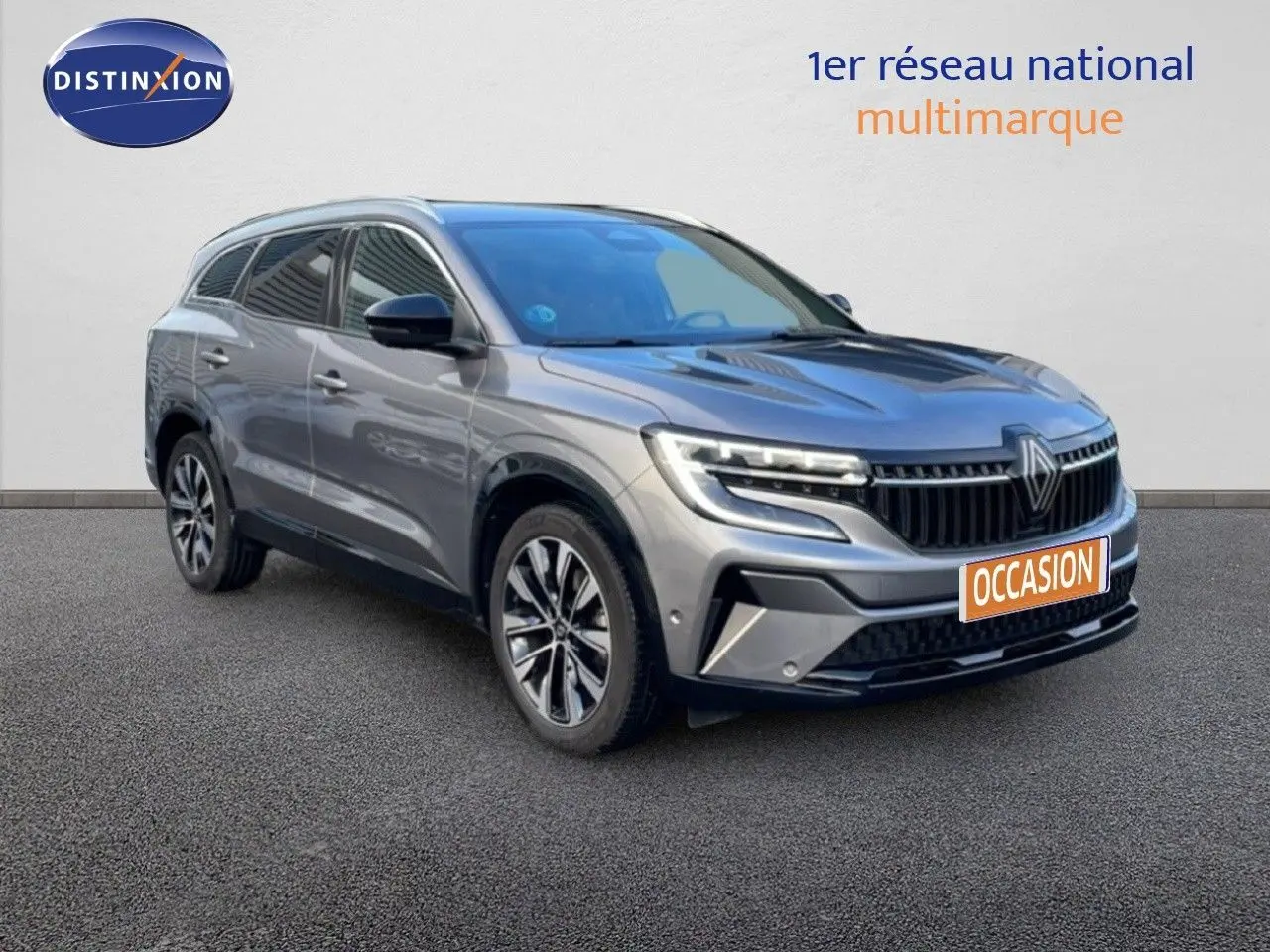 Renault Espace VI E-Tech gris schiste métal, vue 3/4 avant mettant en valeur ses optiques LED et sa calandre distinctive.