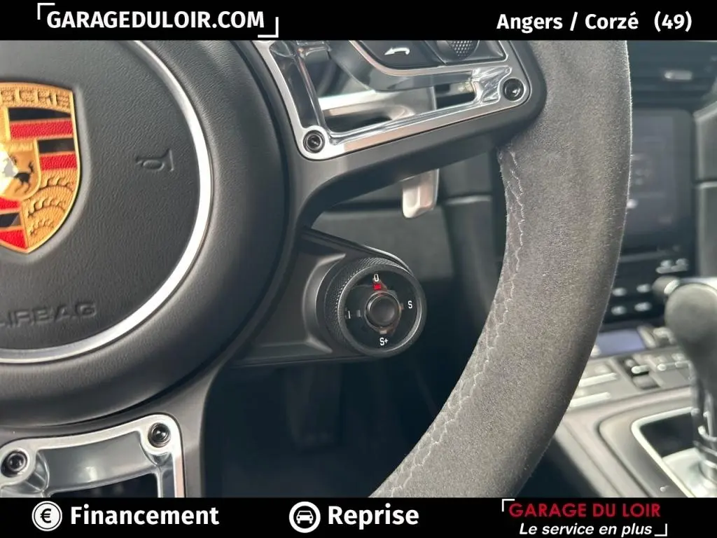 Gros plan sur le volant en alcantara gris de la Porsche 911 Carrera GTS Coupé 2018 avec sélecteur de mode de conduite.