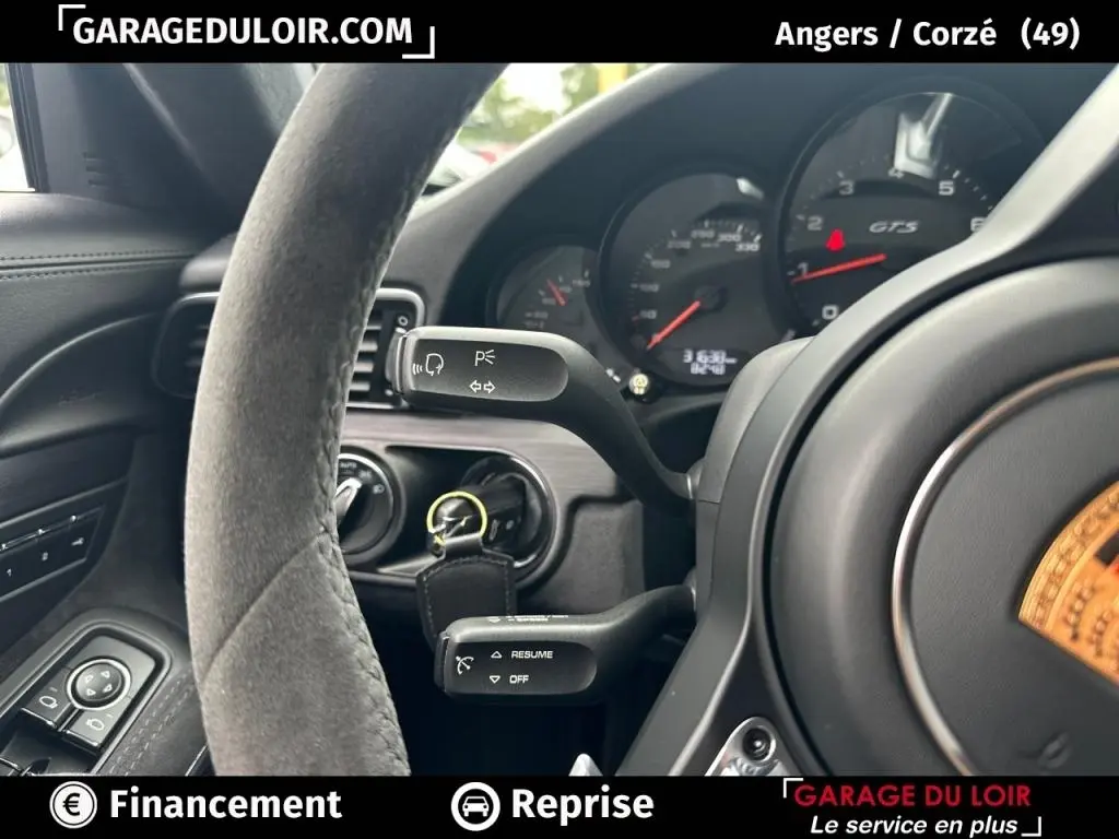 Vue rapprochée du volant en alcantara et du tableau de bord noir avec compteurs GTS de la Porsche 911 Carrera GTS Coupé 2018.